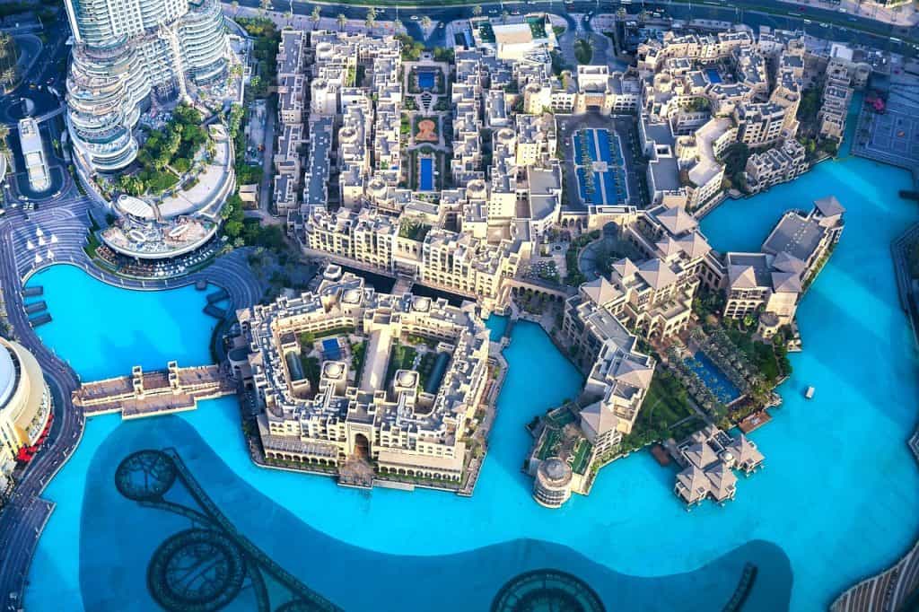 Aerial view of Dubai Water Canal with luxurious buildings and vibrant blue waters, showcasing the ci.